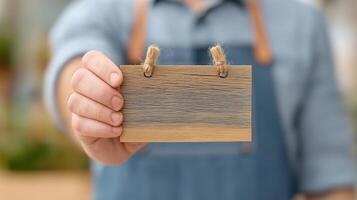 Hand Holding Wooden Card with Twine, Nature Background, Craftsmanship Concept, Close-Up View photo