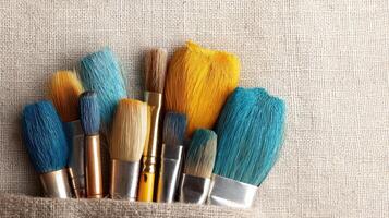 Colorful Art Brushes on Beige Canvas Background for Creative Artwork and Design Projects photo