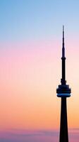 Futuristic Tower Glowing Over Colorful City Skyline at Sunset with Beautiful Gradient in the Sky photo