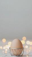 Elegant Egg in Chrome Holder Surrounded by Soft Glowing Lights in a Minimalistic Setting photo