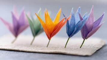 Colorful Paper Flowers Arranged in a Row on a Neutral Background for Arts and Crafts Projects photo