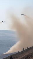 Military Aircraft Flying Over Mountain Landscape with Swirling Dust and Smoky Trails in Clear Sky photo