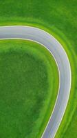 Winding Road Cutting Through Symmetrical Farmland with Lush Greenery and Smooth Curves photo
