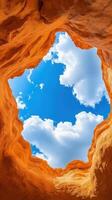 Dreamy Surreal Canyon Cave with Golden Walls Opening to a Bright Blue Sky and Fluffy White Clouds photo