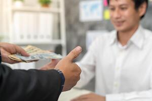 Businessmen receive salary or bonuses from management or Boss. Company give rewards to encourage work. Smiling businessman enjoying a reward at the desk in the office photo