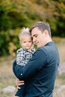 Dad hugs a little girl in his arms, touching her forehead with his forehead photo