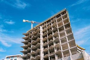 High tower crane builds a multi-storey building with balconies photo