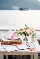 Reception table with a journal of wishes, a set of pencils, markers, beautiful stickers and a bouquet of flowers photo