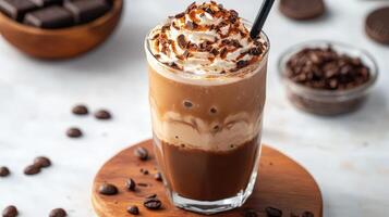A layered chocolate coffee drink with whipped cream topping is displayed photo