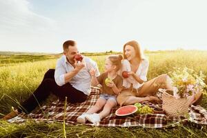 teniendo divertida. emocionado familia teniendo picnic en el campo y comiendo manzanas, mirando a cada otro, Copiar espacio foto