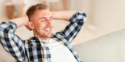 Resting Concept. Close up portrait of man relaxing at home on couch, enjoying free time and daydreaming photo