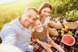 Selfie Time. Lovely family having picnic in nature and making photo together, smiling at camera