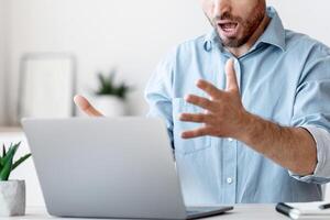 Computer Problems. Angry Businessman Shouting At Laptop In Office, Emotionally Reacting To System Error, Free Space photo