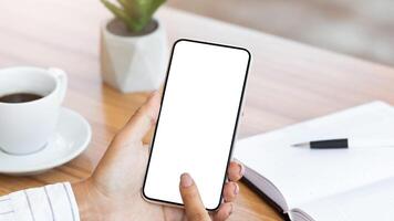 View over the shoulder of girl using cell phone, touching gadget with white blank screen, mock up, copy space photo