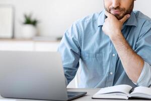 Thoughtful Businessman Working With Computer In Office, Looking At Laptop Screen, Thinking About Business Solution, Copy Space photo