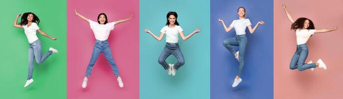 Group Of Five Multicultural Women Jumping Posing In Mid-Air In Different Poses Having Fun Over Colorful Studio Backgrounds, Smiling To Camera. Bright Colored Collage, Panorama, Full Length photo