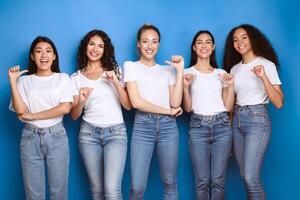Choose Me. Diverse Girls Pointing At Themselves Smiling To Camera Posing In Studio Over Blue Background. photo