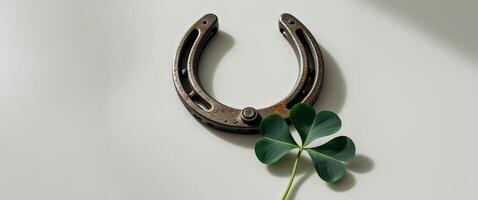 horseshoe with a four leaf clover next to it. photo