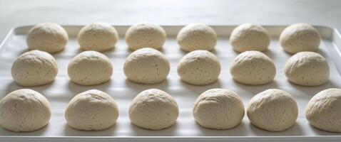 Raw Dough Balls Arranged on Tray for Proofing. photo