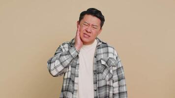 Asian man touching cheek closing eyes with expression of terrible suffer from painful toothache video