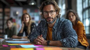 Man sitting at table with other people in background photo
