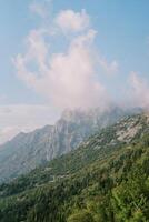 Fog over the peaks of a mountain range against a cloudy sky photo