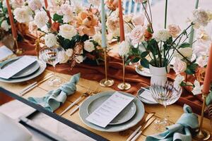 Bouquets of flowers stand on the table next to the festive menu on plates photo