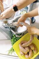 Chef and assistant make sausage on an electric meat grinder photo