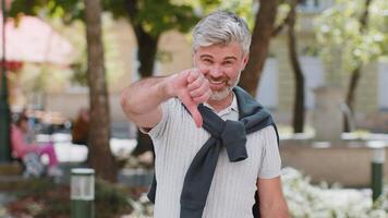 Mature man showing dislike thumbs down sign gesture expressing discontent disapproval dissatisfied video