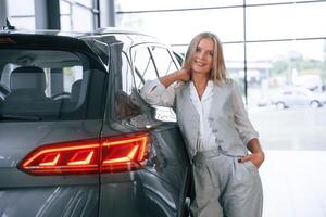 Woman, in, formal clothes is in the car dealership photo