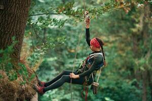 Woman is doing ,climbing in the forest by the use of safety equipment photo