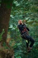 Activity, hanging on a rope. Man ,is, doing climbing in the forest by use of safety equipment photo