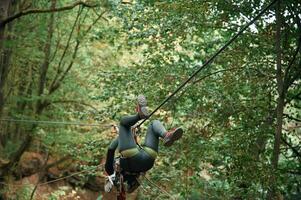Climbing in the, forest. Woman, is, in the forest using the safety equipment photo