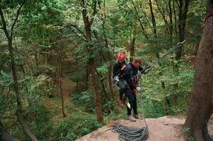In the, forest. .Man and woman doing climbing with use of safety equipment photo