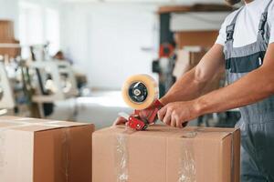 Packing the product. Handsome man ,,is, working at the factory of creating eco boxes photo