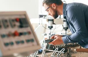 Operating, the, machine. Handsome man is working at the factory of creating eco boxes photo