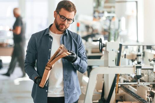 Front, view. Handsome, man is working at the factory of creating eco boxes photo