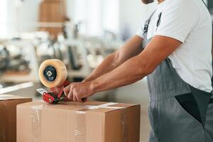 Close, up ,view. Man is working at the factory of creating eco boxes photo