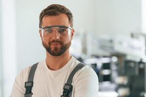 Close, up portrait. Handsome, man is working at the factory of creating eco boxes photo