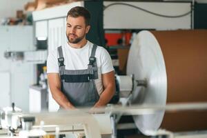 Smart engineer. Handsome ,,man is working at the factory of creating eco boxes photo