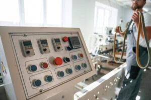 Standing by ,the machine. Handsome man is working at the factory of creating eco boxes photo