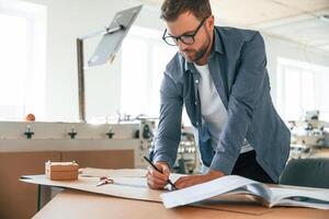 Business, planning. Handsome, man is working at the factory of creating eco boxes photo