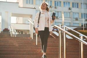 With water bottle.. Young, female student in casual clothes is outdoors photo
