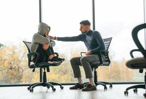 On the chairs, near, window. Depressed woman is at an appointment with a psychologist photo
