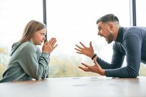 Side, view, near big window. Man is screaming at his girlfriend, conception of quarrel photo