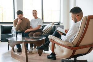 Man, is writing ,notes. Couple at a psychologist's appointment photo