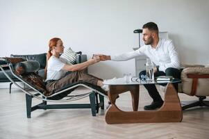 Side view.. Woman is sitting in chair at an appointment with a psychologist photo