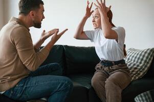 Side view ,of ,couple that are arguing. Sitting on sofa photo
