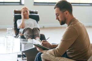 Life ,,problems. Woman is sitting in chair at an appointment with a psychologist photo