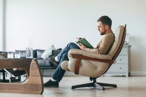 Male ,psychologist is sitting in the chair with notepad in the office photo